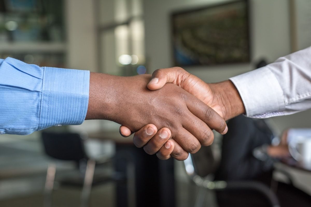 Executive handshake in a professional boardroom setting, representing Consolidated Solutions LLC's partnership approach